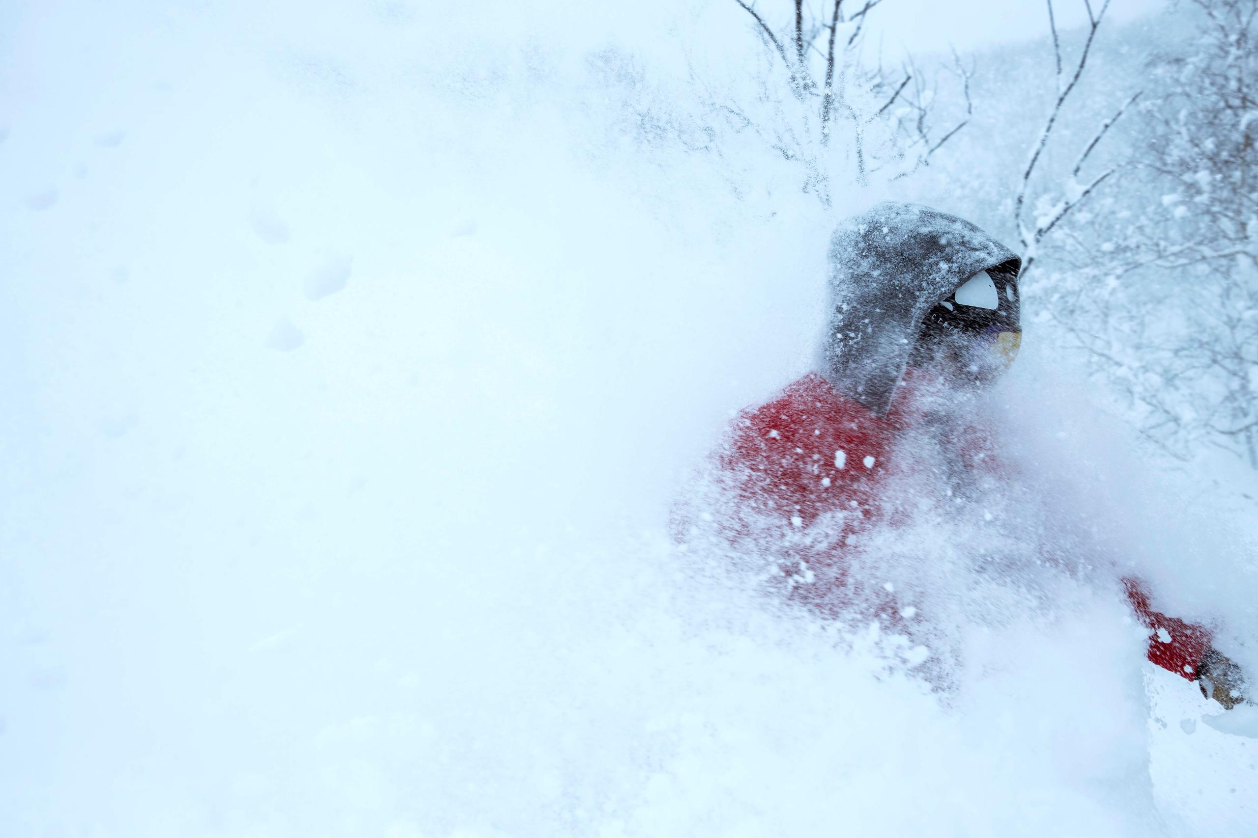 Man completely covered in deep powder skiing in Hokkaido Japan