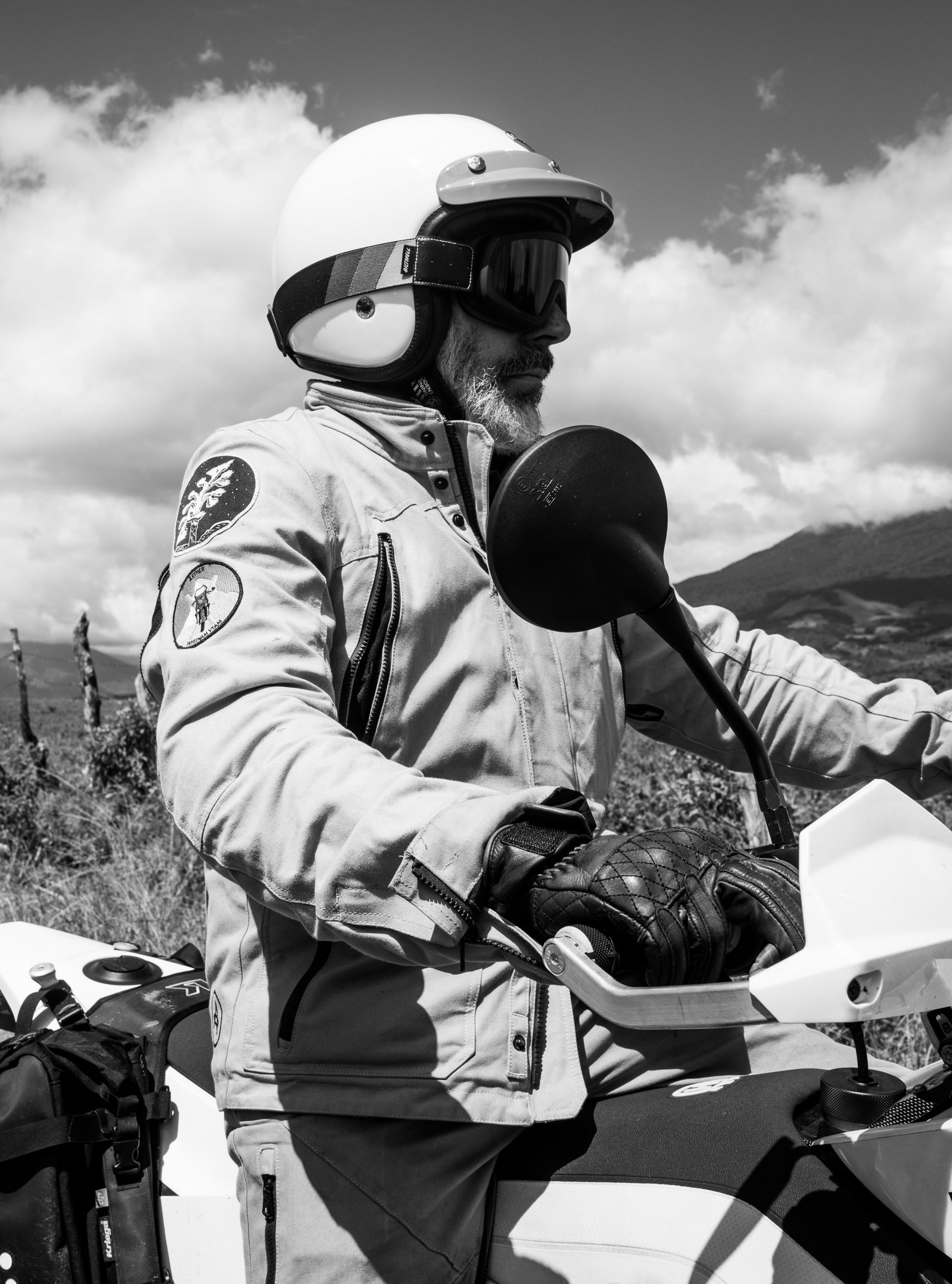 Black and white photo of man riding motorcycle in Costa Rica countryside