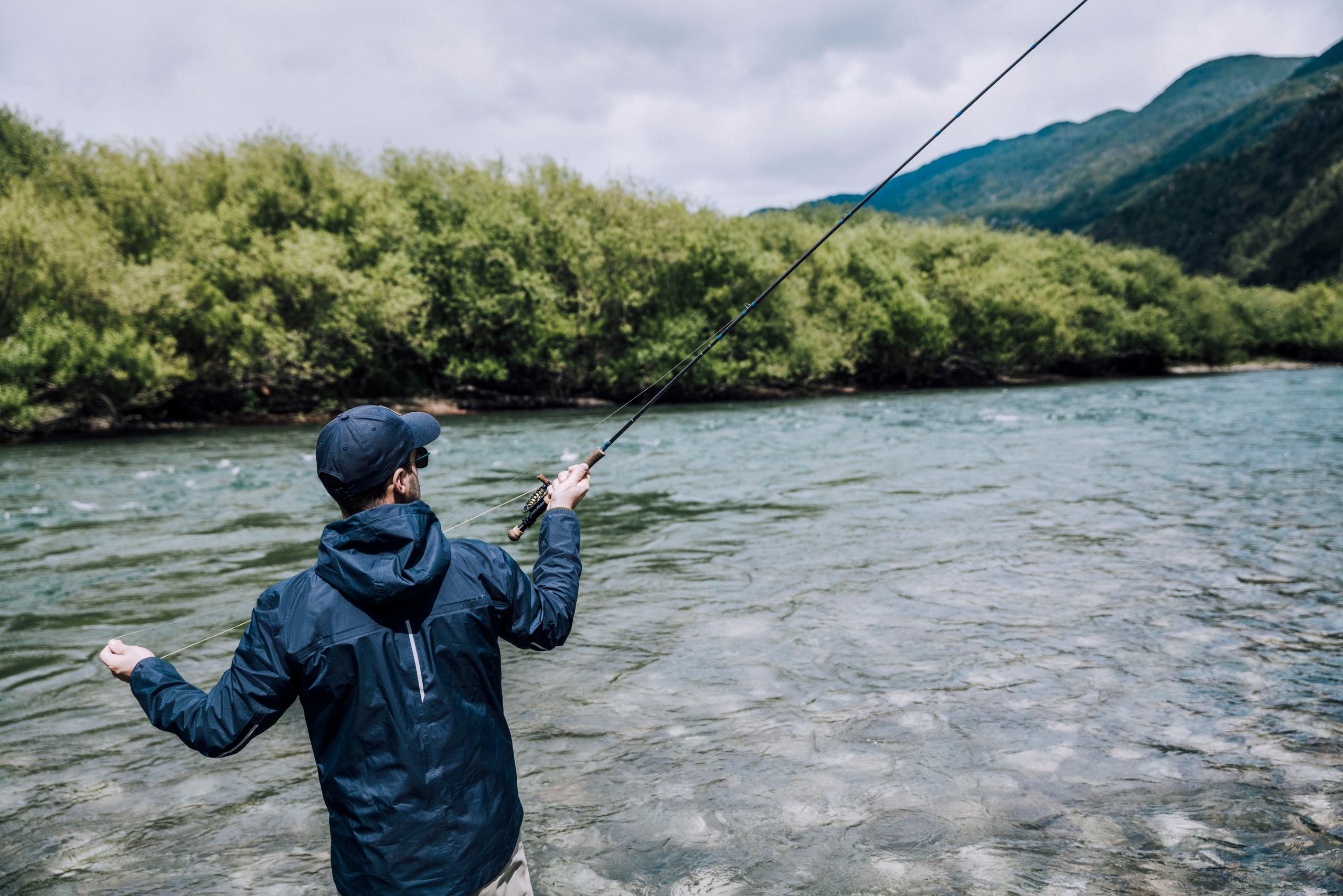 Man in Storm Jacket casting fishing line in Patagonia river