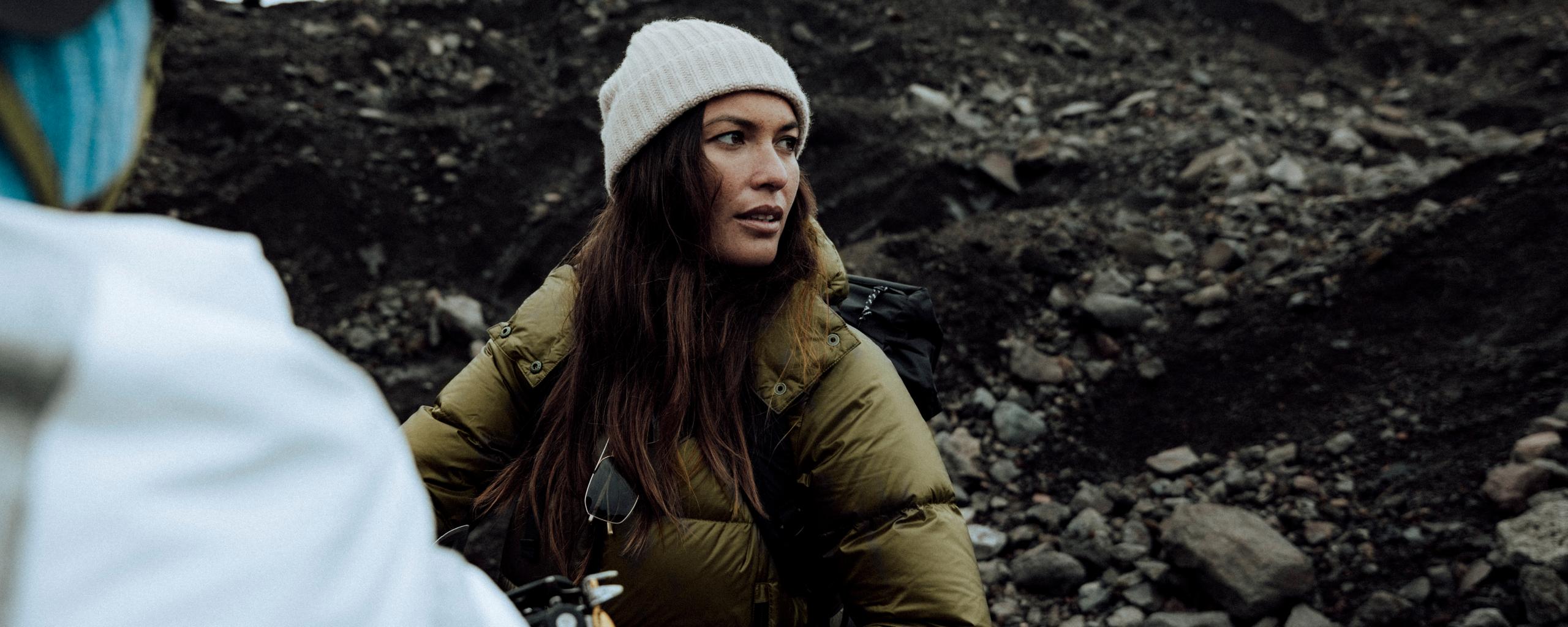 Woman wearing puffer jacket on rocky Iceland terrain