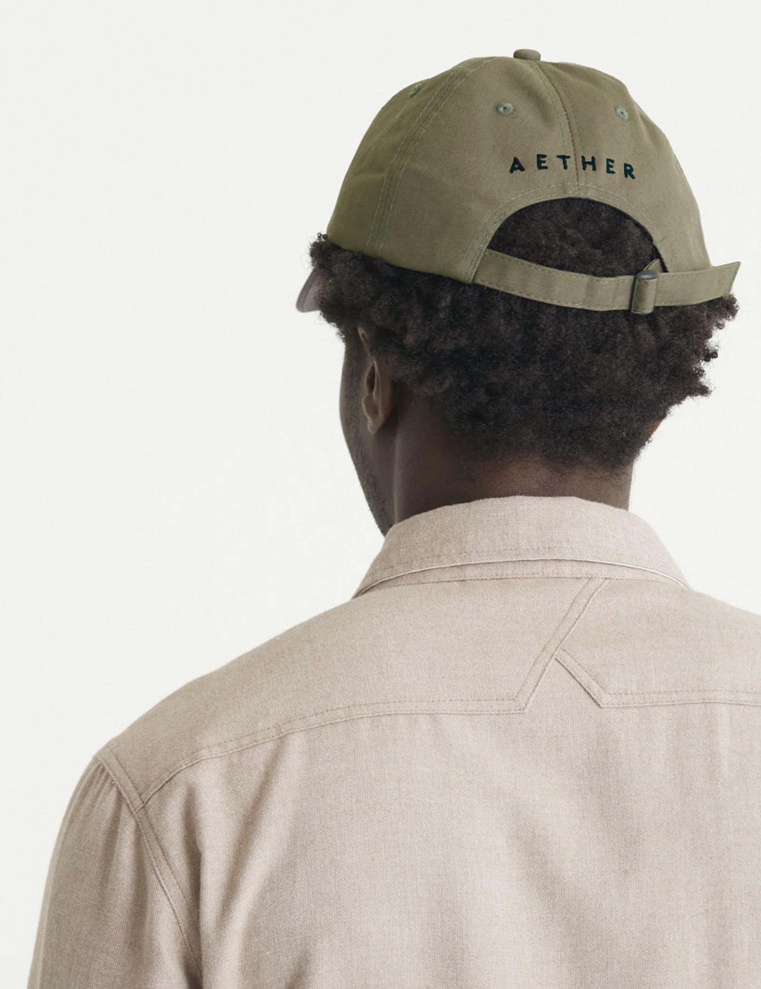 Man holding brim of Cotton Ripstop Hat in studio