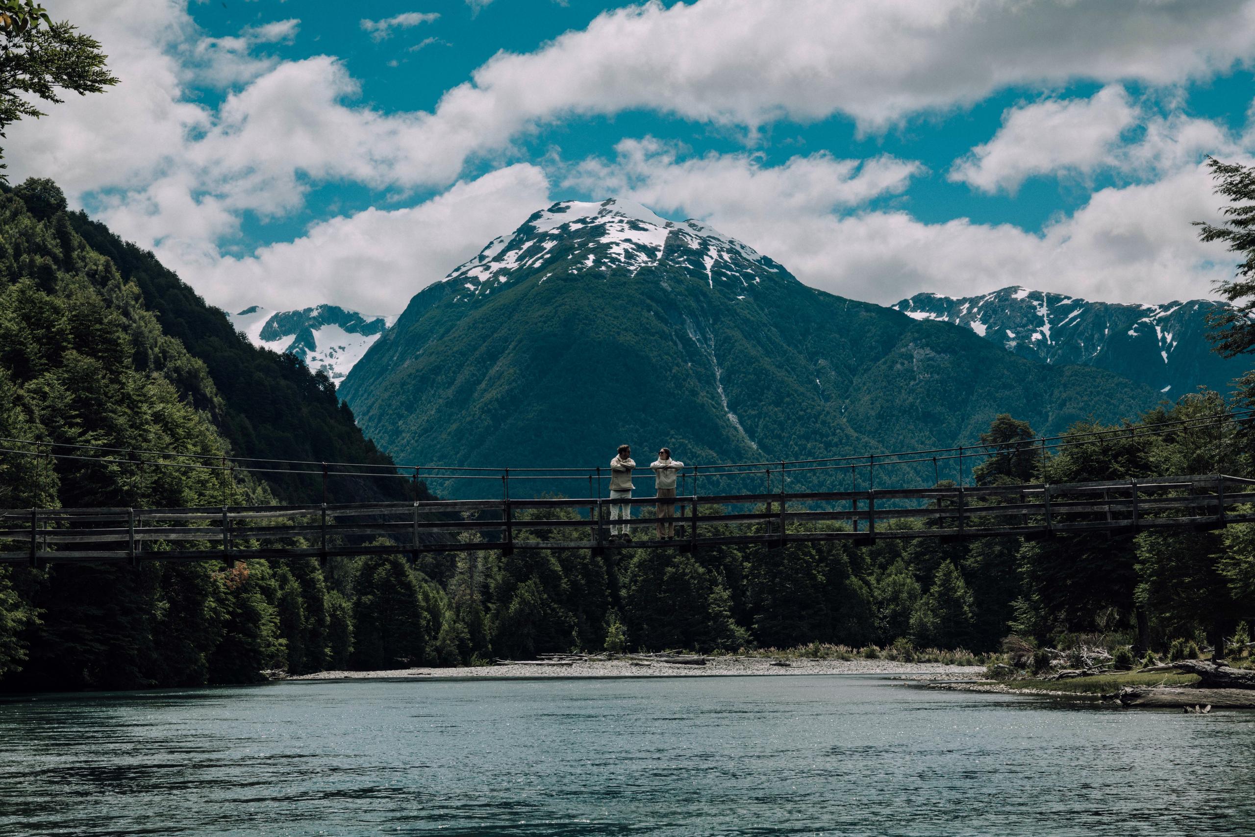 Man and woman standing on suspension bridge in Patagonia