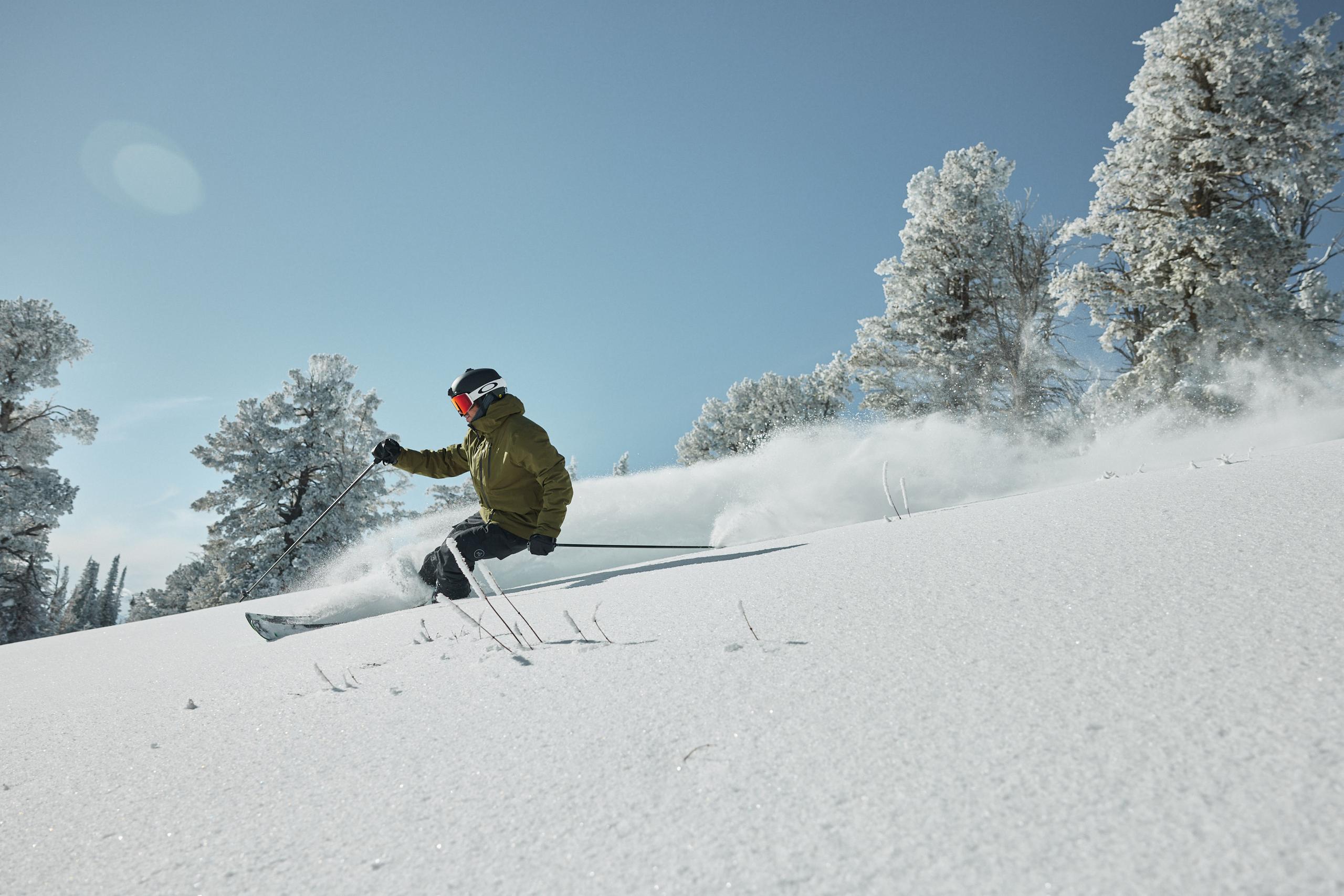 Skier going down mountain on blue sky day