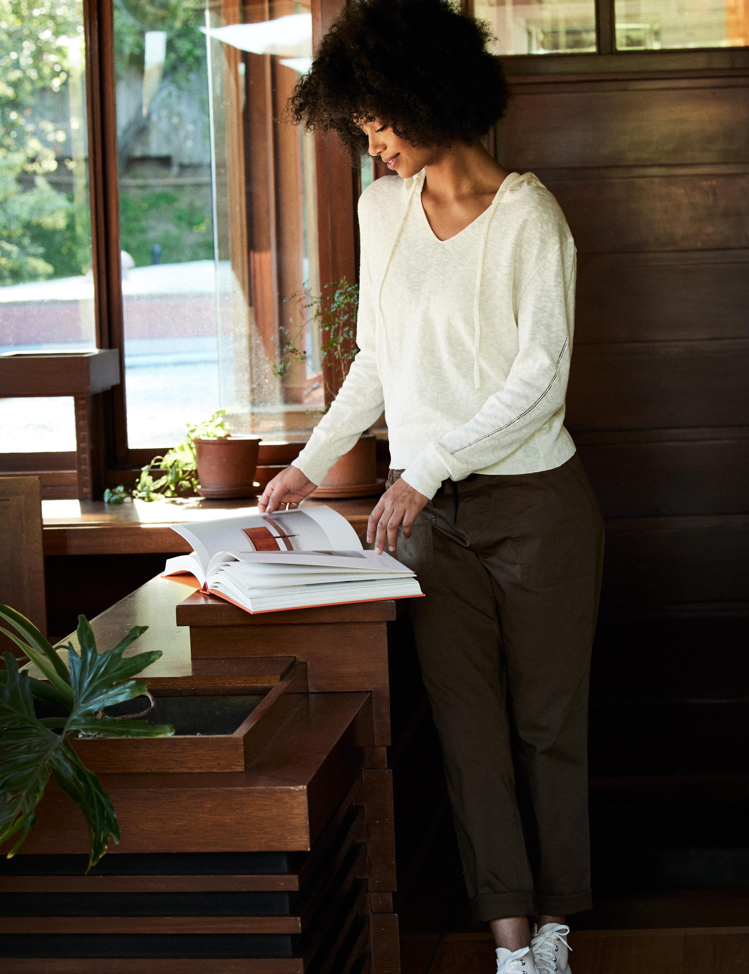 Woman wearing Lightweight Linen Sweater looking at a photo book
