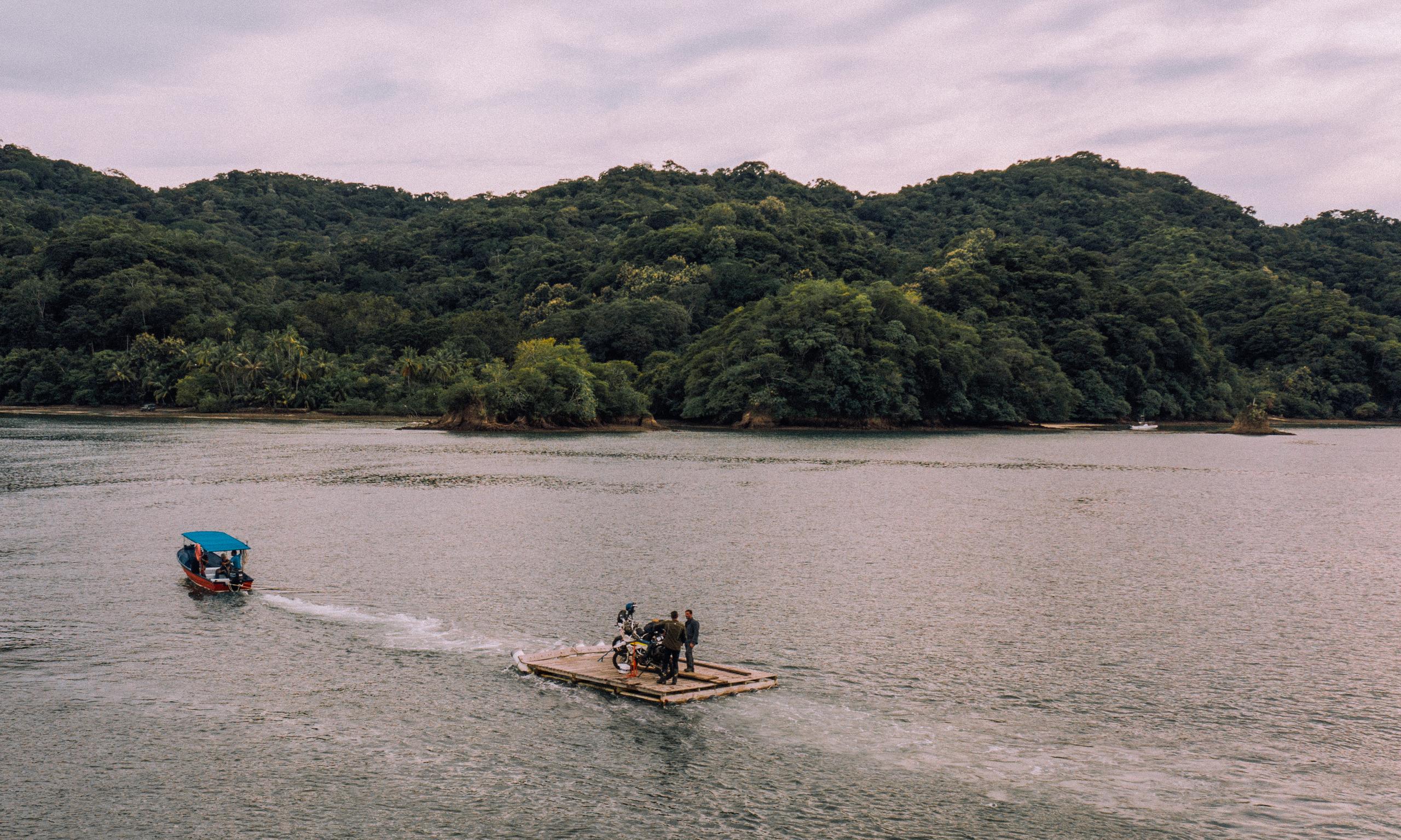 Transporting motorcycles on a raft across a river in Costa Rica