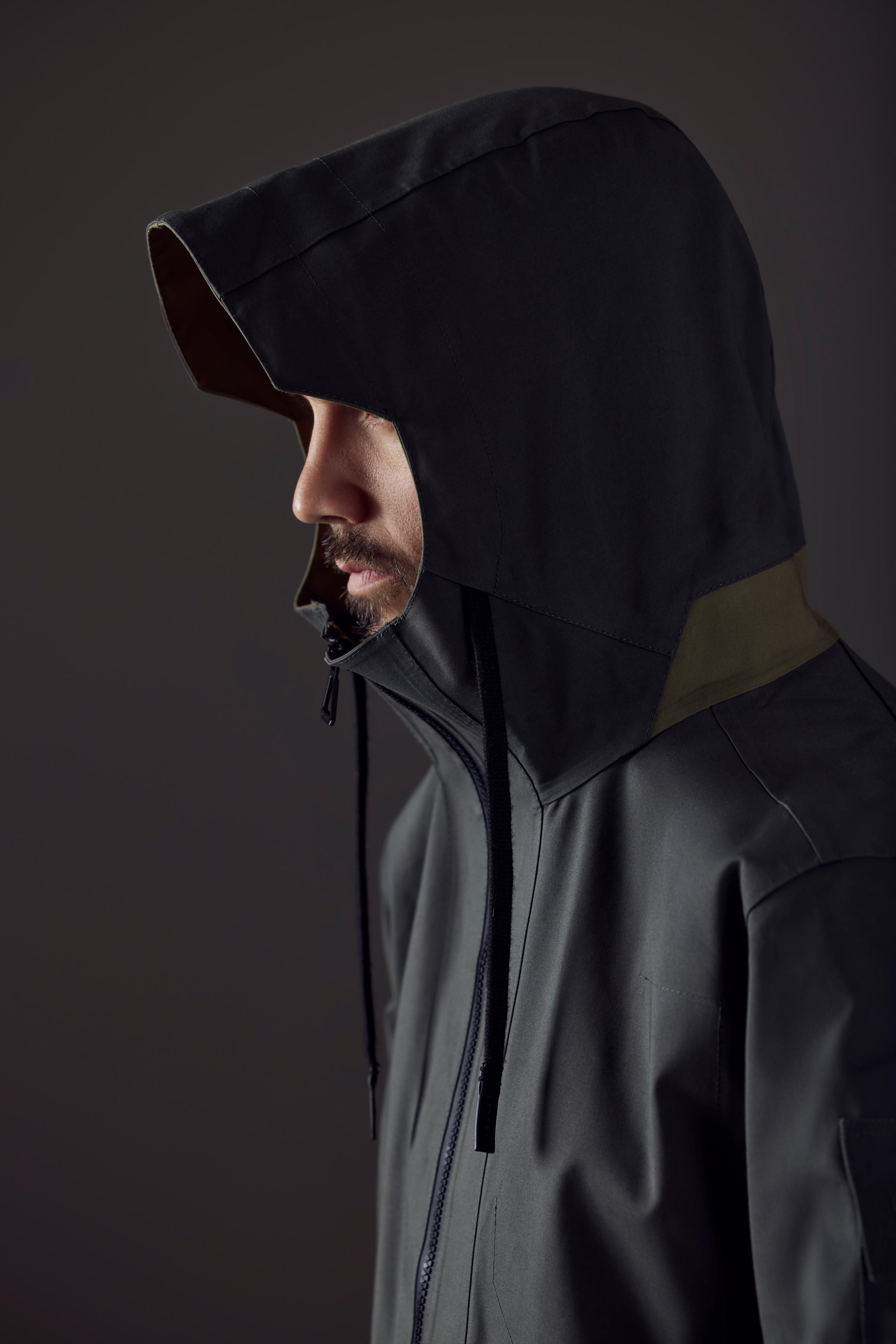 Studio profile of man wearing AETHER + Mackintosh Anorak with hood
