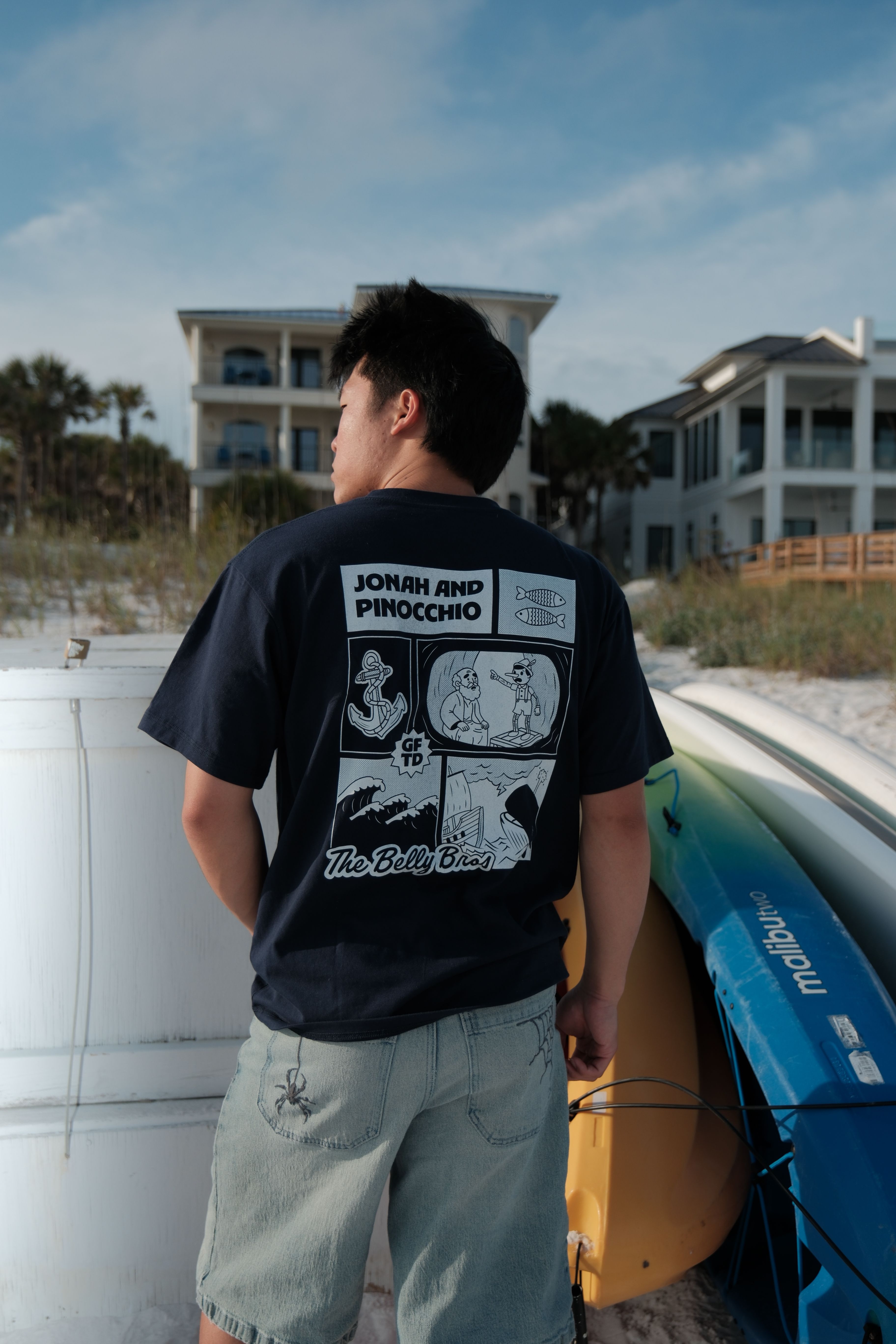 A guy on a beach wearing GFTD Jonah tee in navy