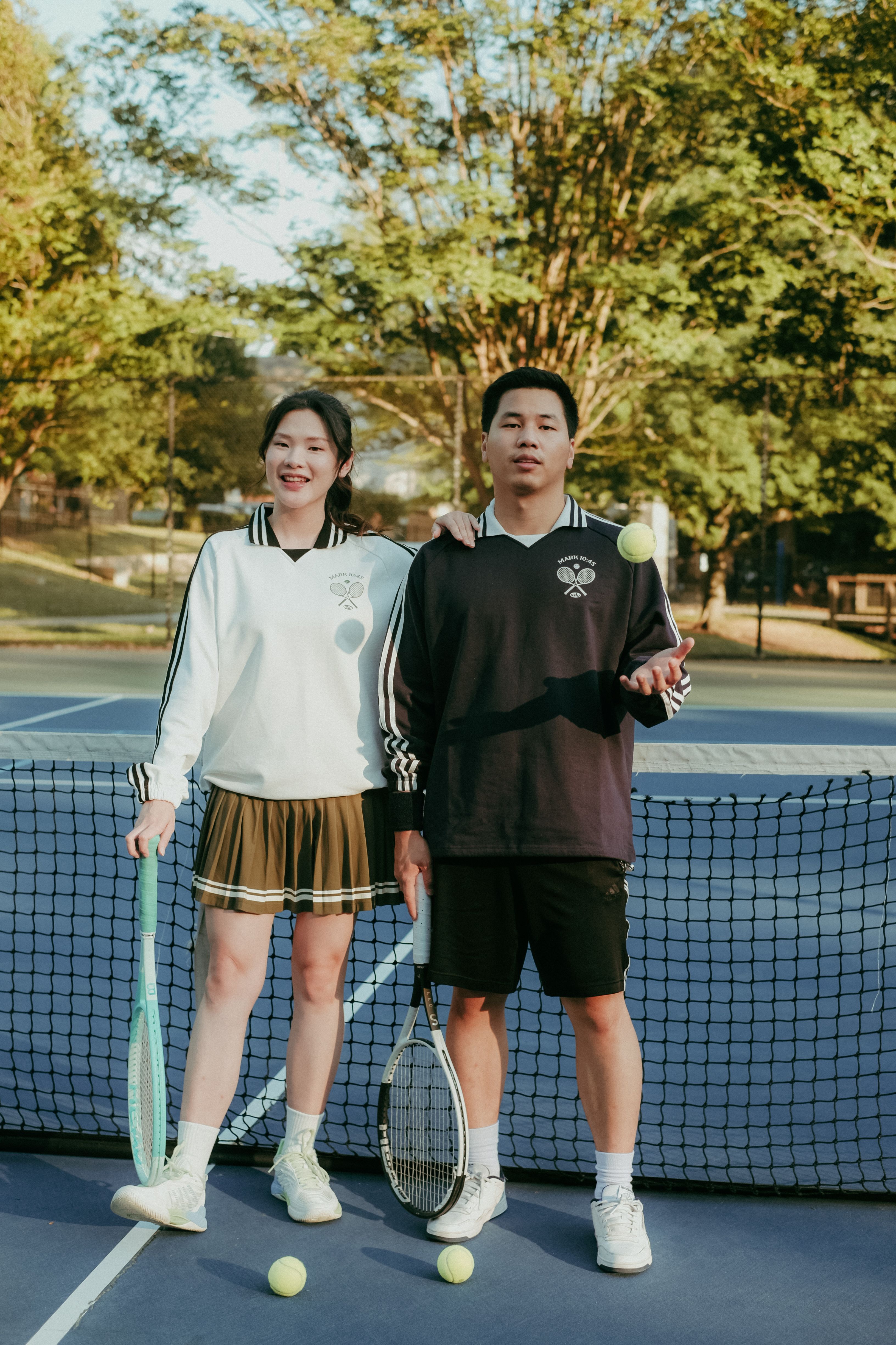 A guy and a girl wearing GFTD Jesus Came to Serve Tennis Pullovers in white and navy