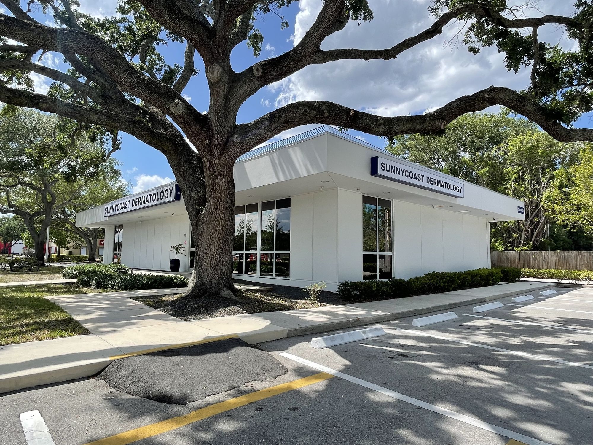 Sunnycoast Dermatology office in Vero Beach, Florida, beneath a live oak tree