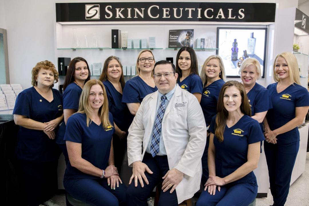 Sunnycoast Dermatology team in navy scrubs with Dr. Ted Rudolph in a white coat