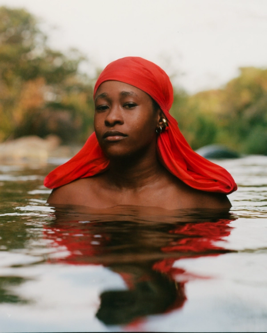 a woman wearing a red head scarf is swimming in the water