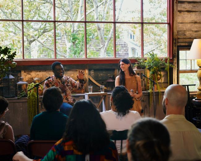 a group of people are sitting in front of a microphone in a room .