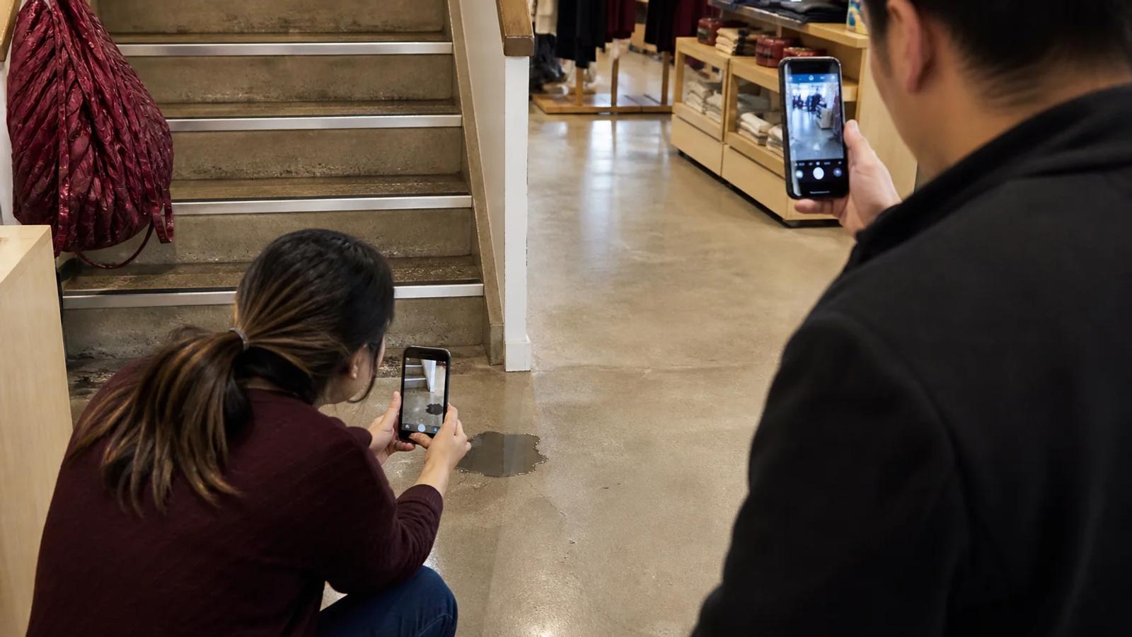 A companion safely photographing a floor hazard, warning sign, shoe, and nearby security camera after a fall