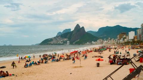 people relaxing on ipanema beach in rio de janeiro, brazil
