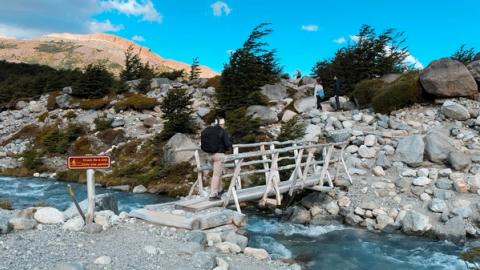 woman crossing Río Eléctrico while hiking in el chalten, argentina