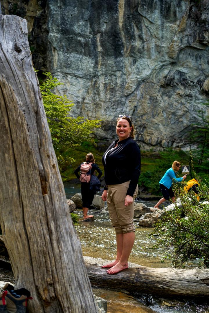 woman standing in the water at Chorrillo del Salto waterfall in el chalten, argentina