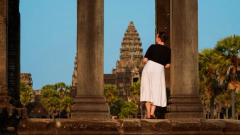 woman watching the entrance of angkor wat in siem reap, cambodia