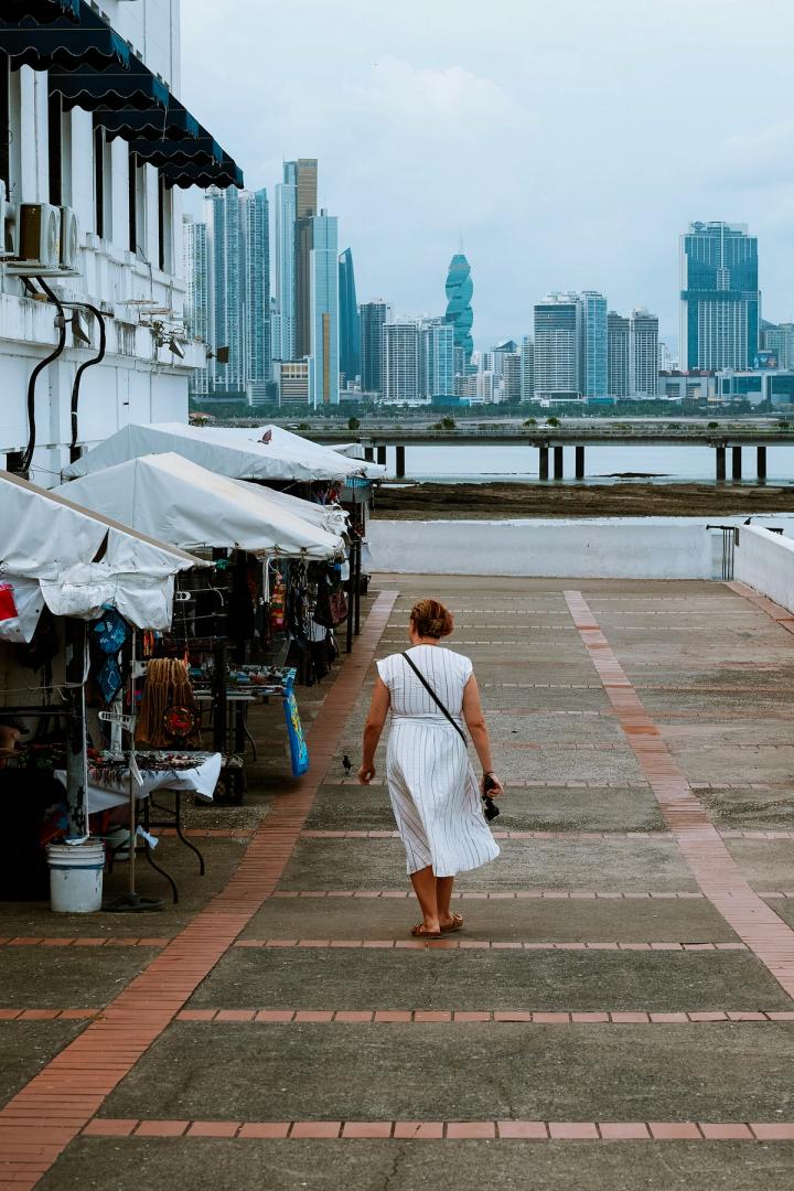woman walking along a row of stalls selling souvenirs in panama city, panama