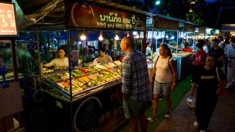 people shopping food at the night market in luang prabang, laos