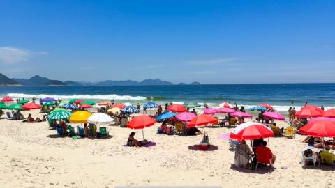 people relaxing on copacabana beach in rio de janeiro, brazil
