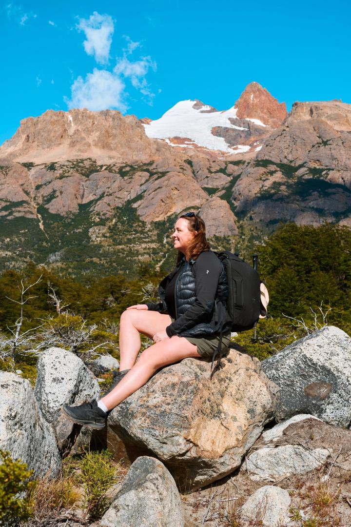 woman sitting on a rock while hiking in patagonia in el chalten, argentina