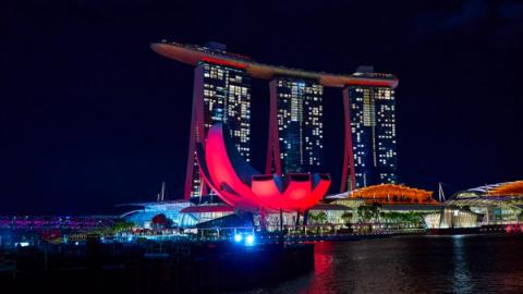 Marina bay hotel and art science museum lit up in red at night, Singapore