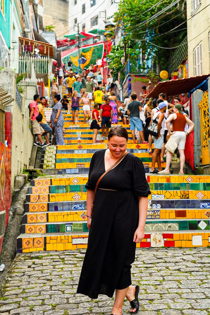 woman standing in front of the selaron steps in rio de janeiro, brazil