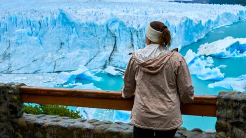 woman standing in front of perito moreno glacier in el chalten, argentina