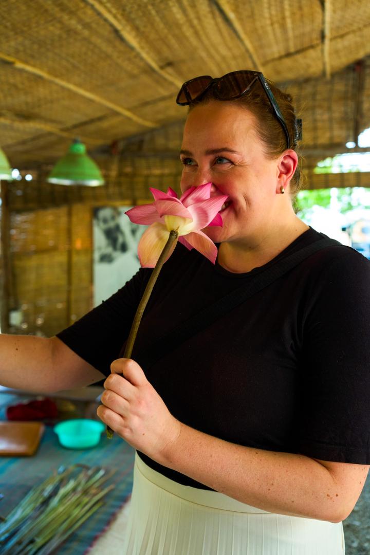 woman smelling a lotus flower in siem reap, cambodia