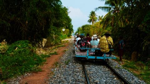 a group of people taking the bamboo train in battambang, Cambodia