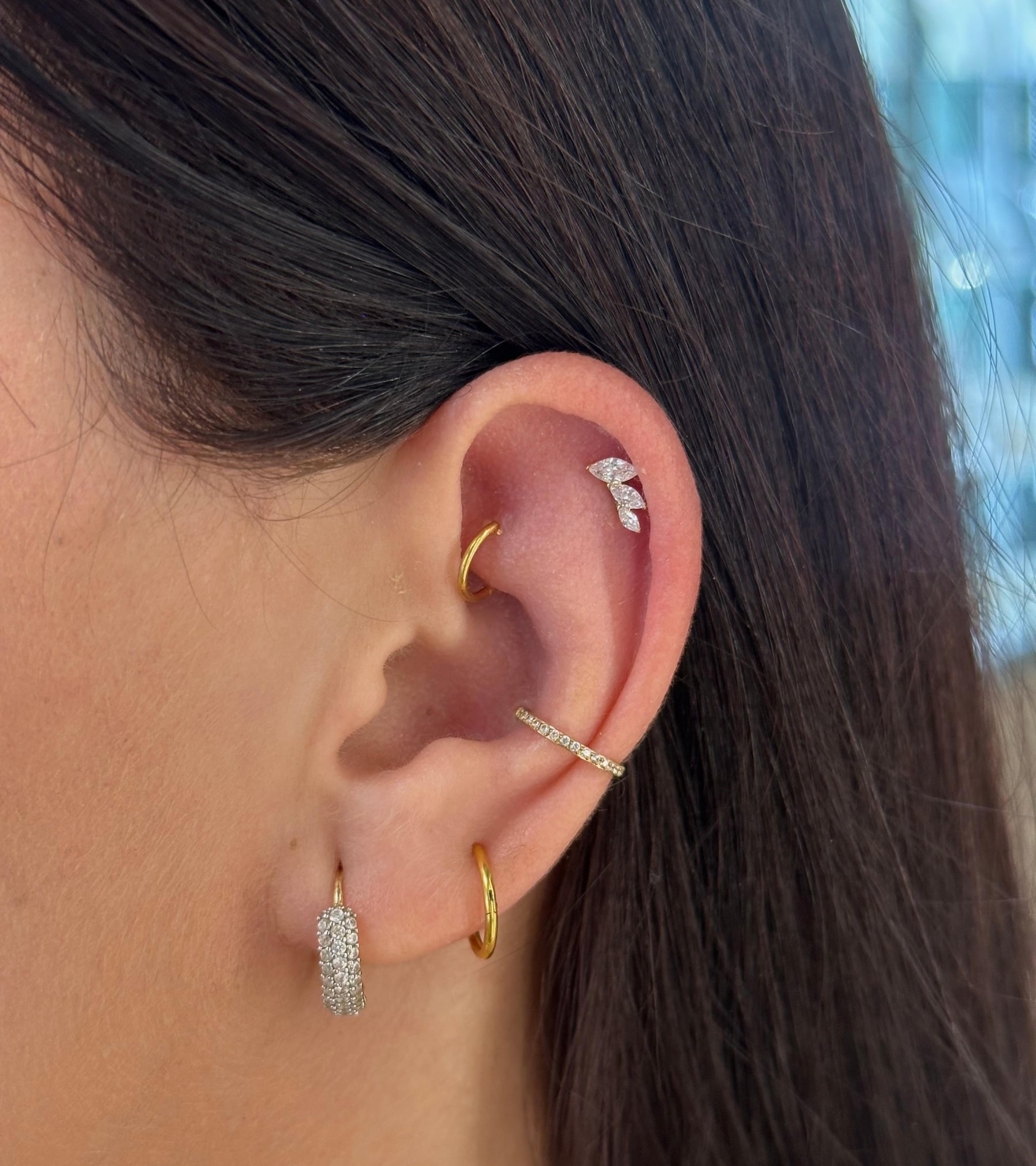 Ucho s piercingami helix, daith, conch a lalok