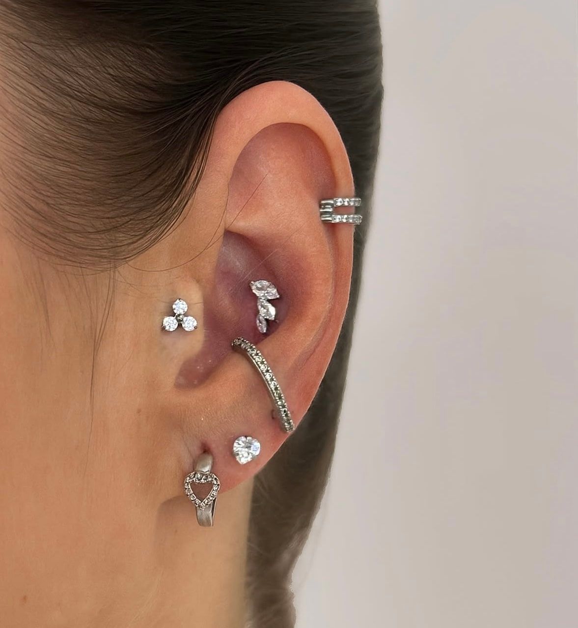 Ucho s piercingami helix, tragus, conch a lalok