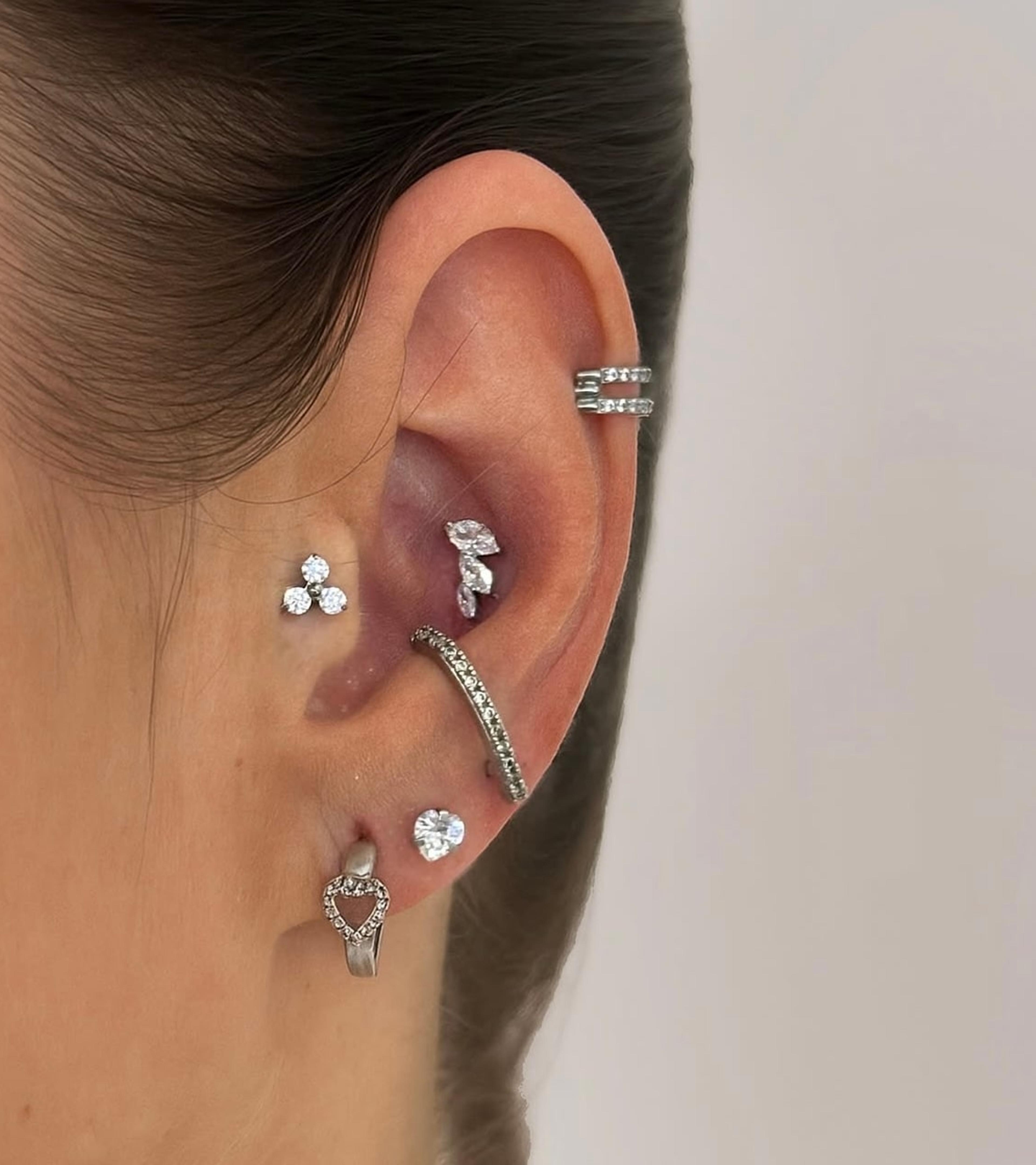 Ucho s piercingami helix, tragus, conch a lalok
