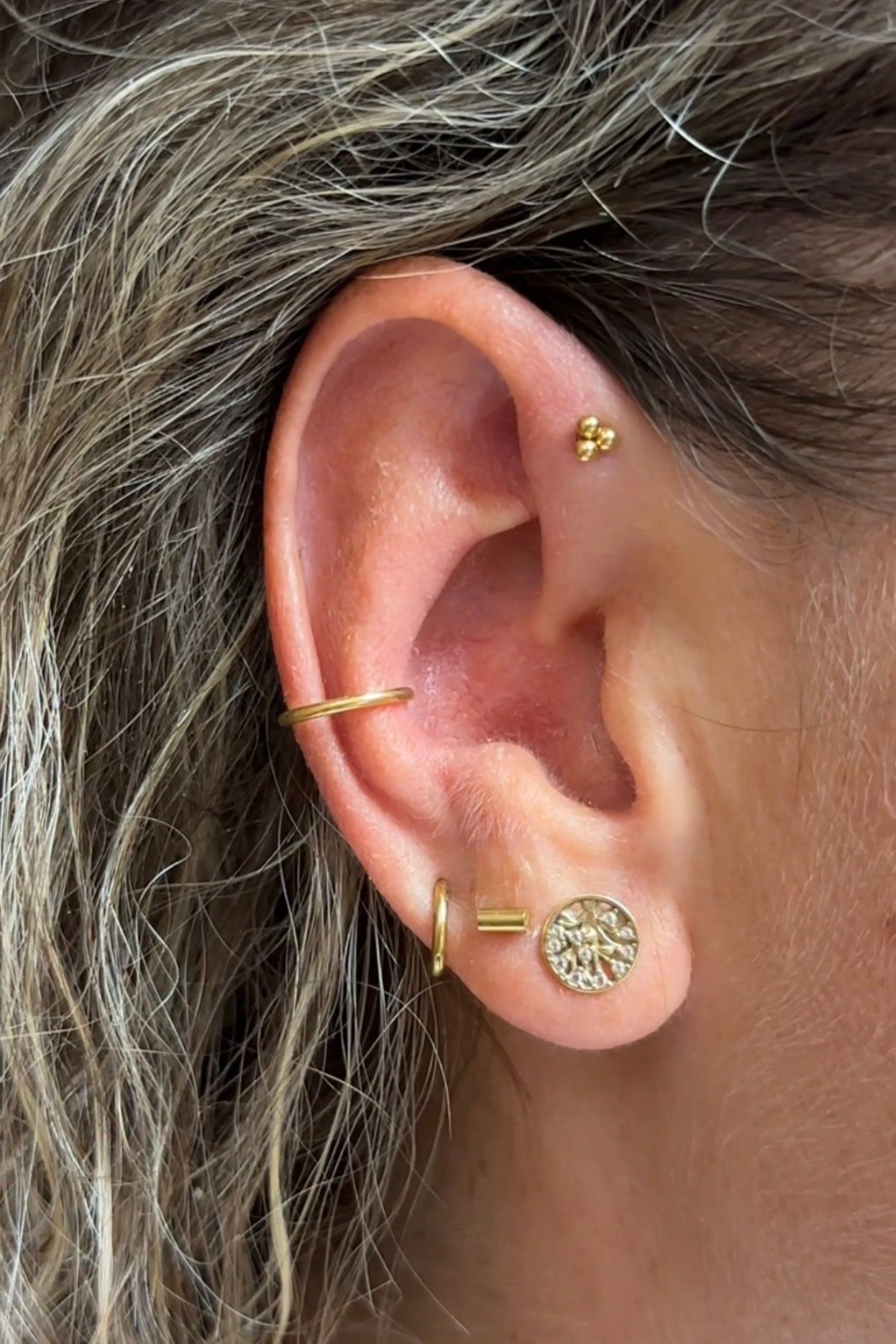 Ucho s piercingami helix, conch a lalok