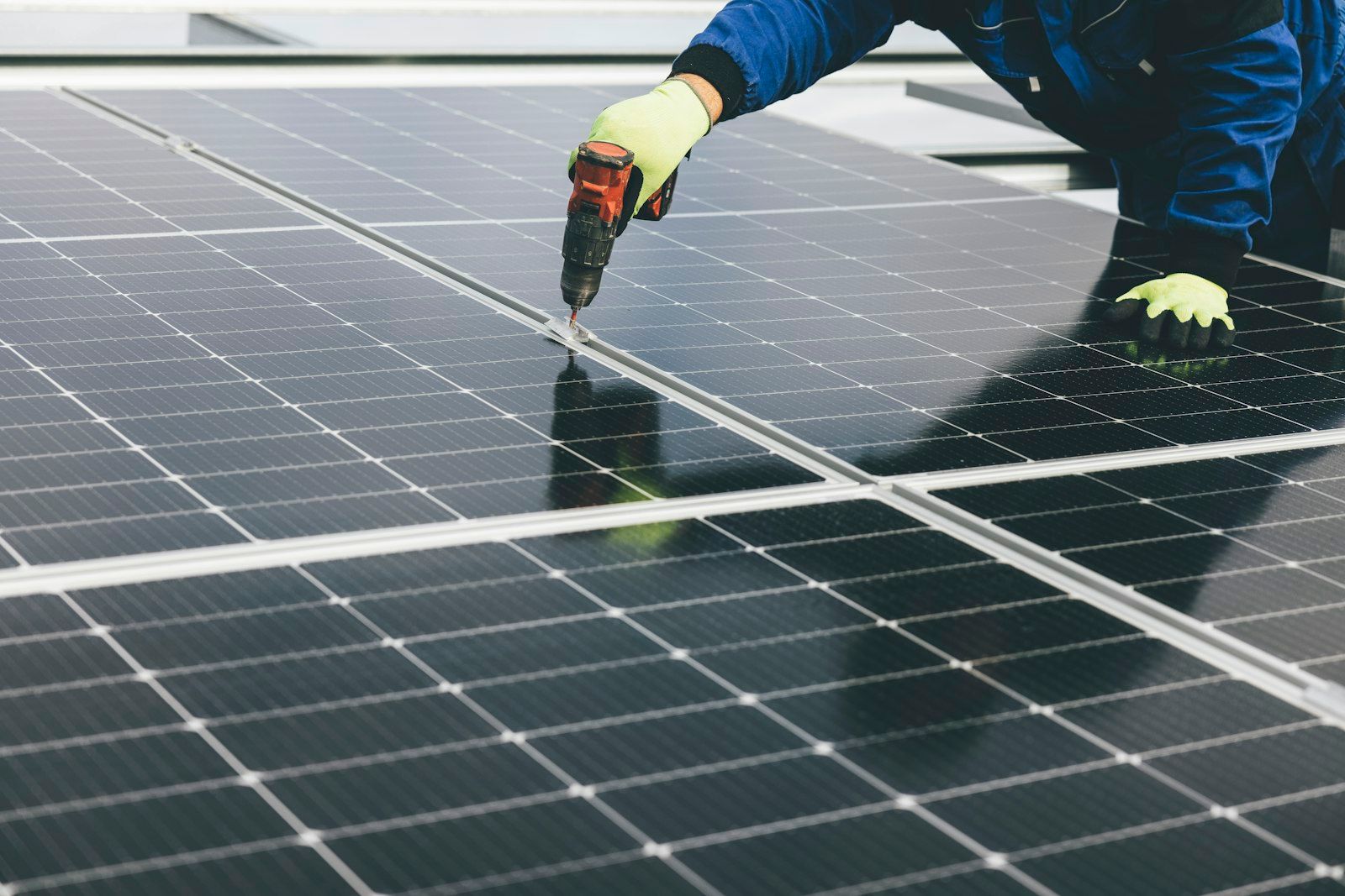 Tecnico instalando modulos fotovoltaicos em usina solar.