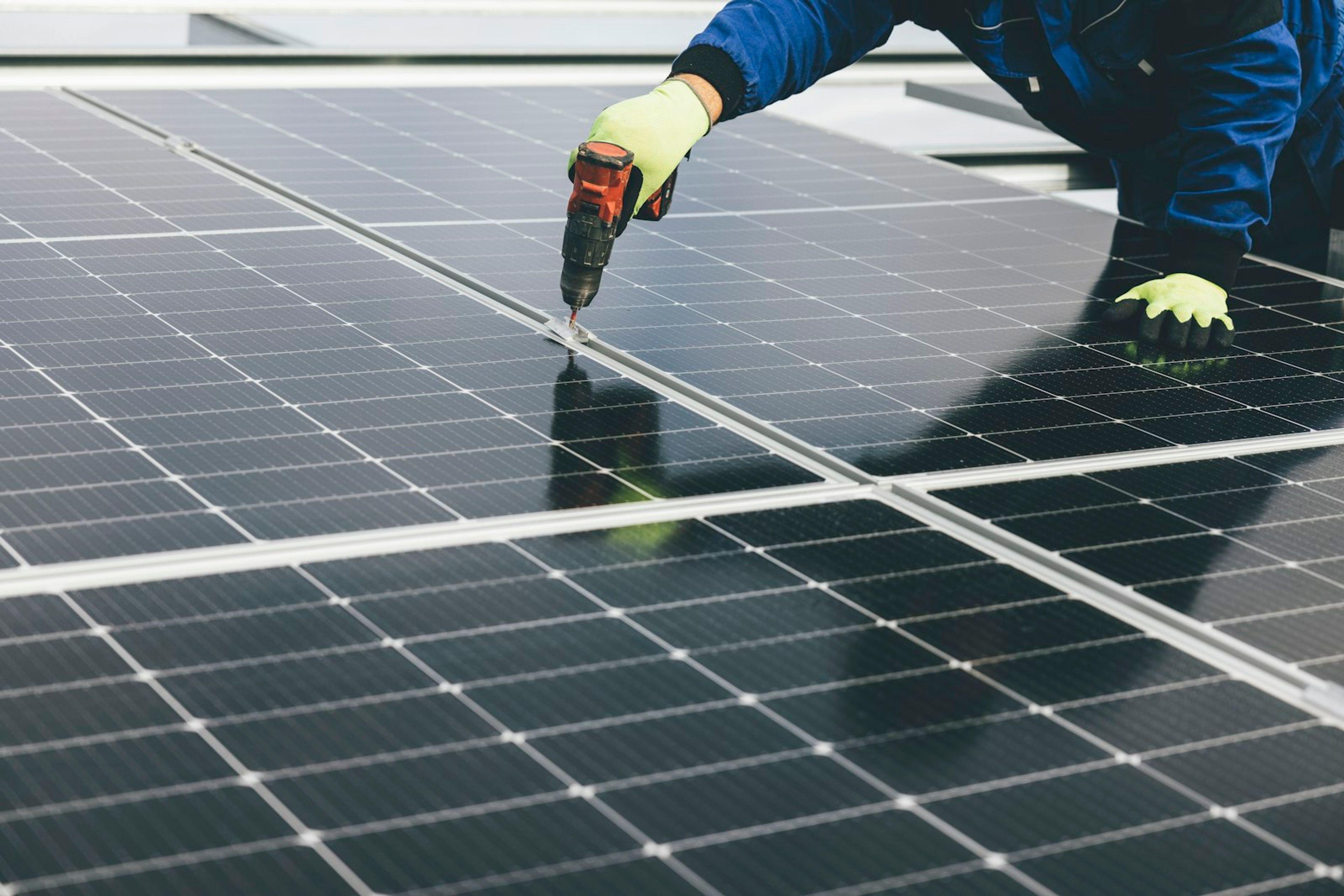Tecnico instalando modulos fotovoltaicos em usina solar.