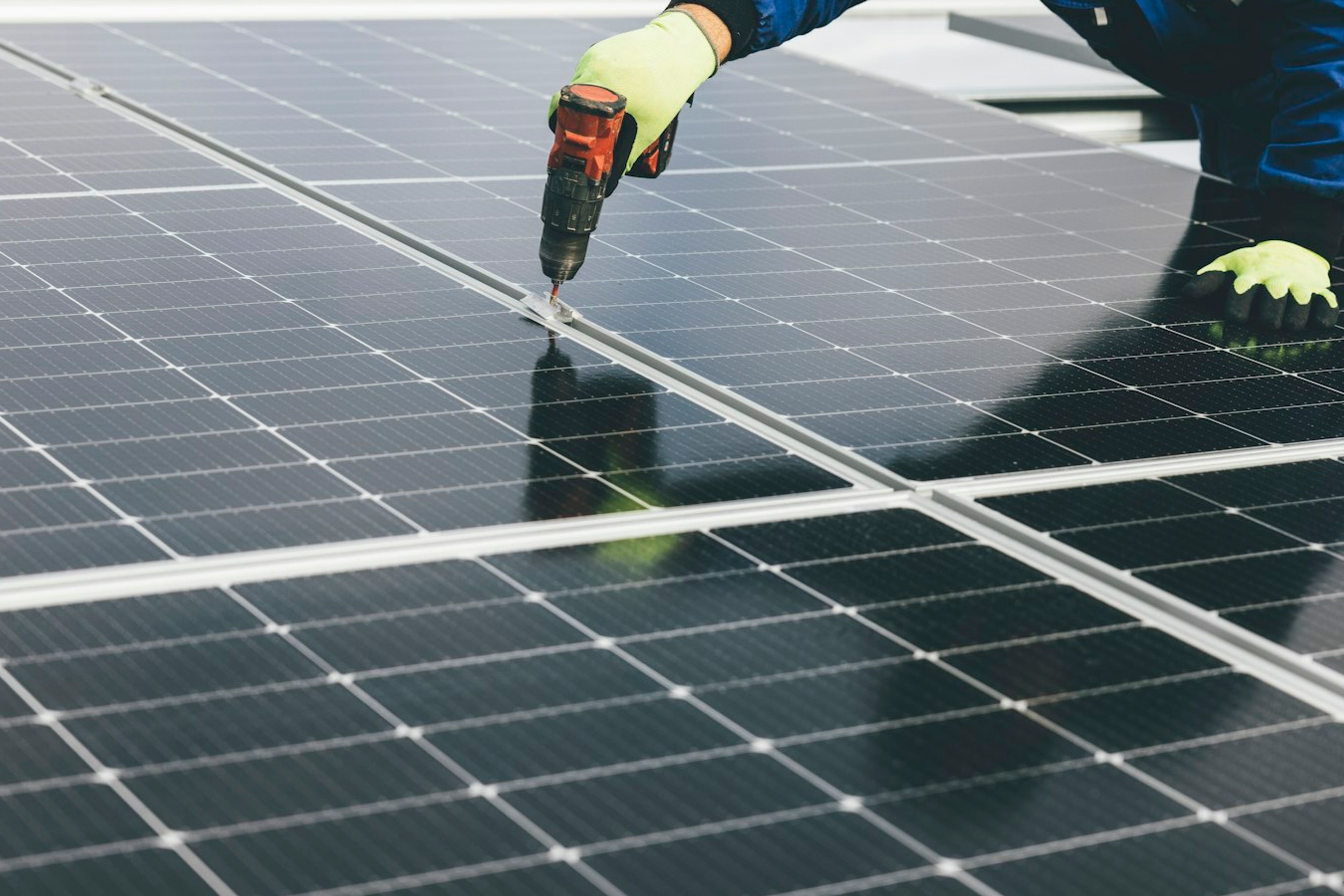 Tecnico instalando modulos fotovoltaicos em usina solar.