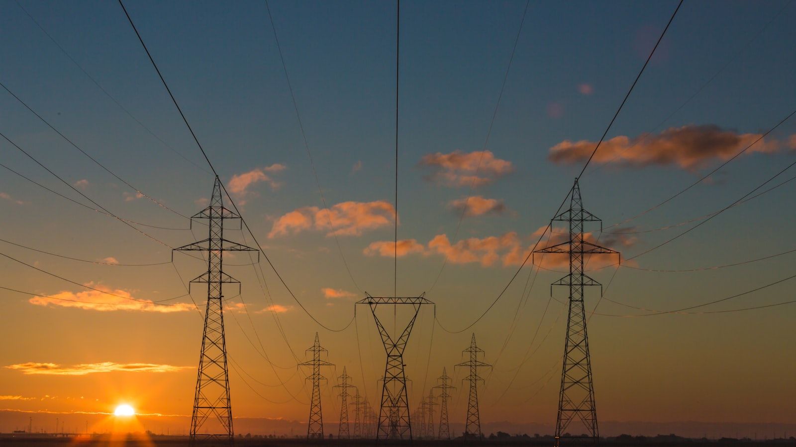 Torres de transmissão de energia elétrica ao pôr do sol.