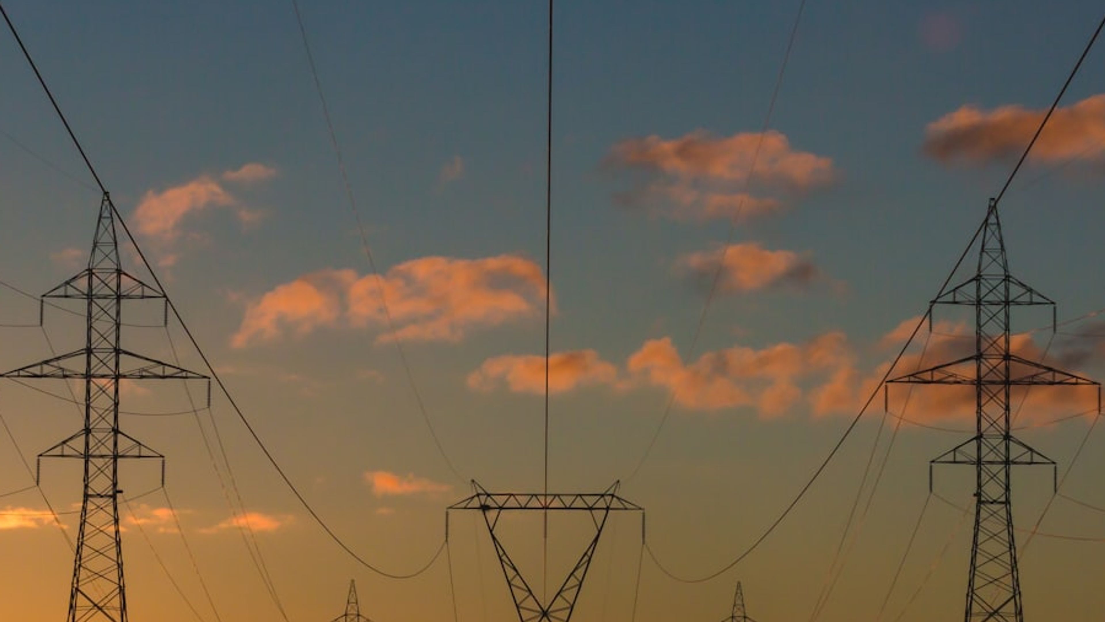 Torres de transmissão de energia elétrica ao pôr do sol.