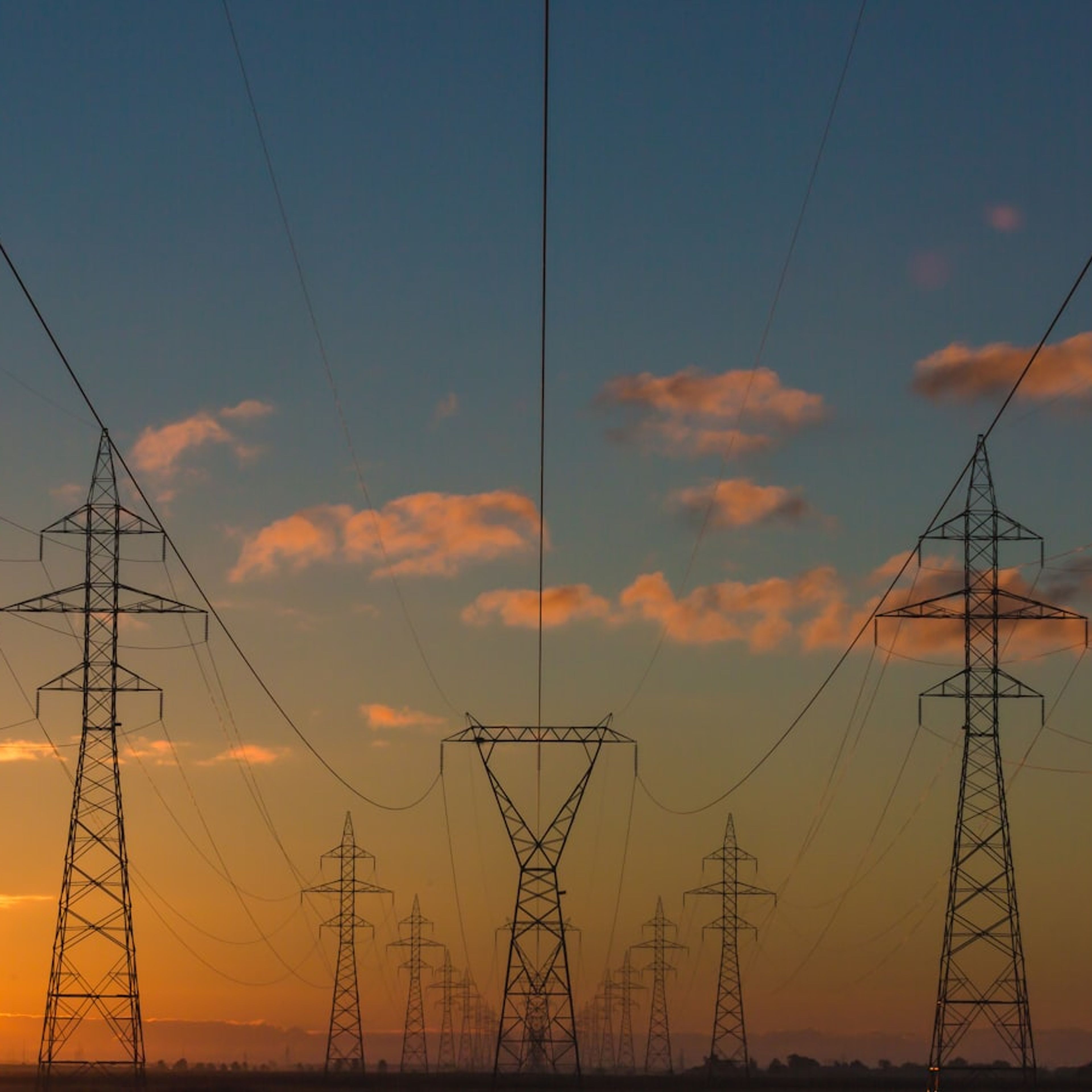Torres de transmissão de energia elétrica ao pôr do sol.