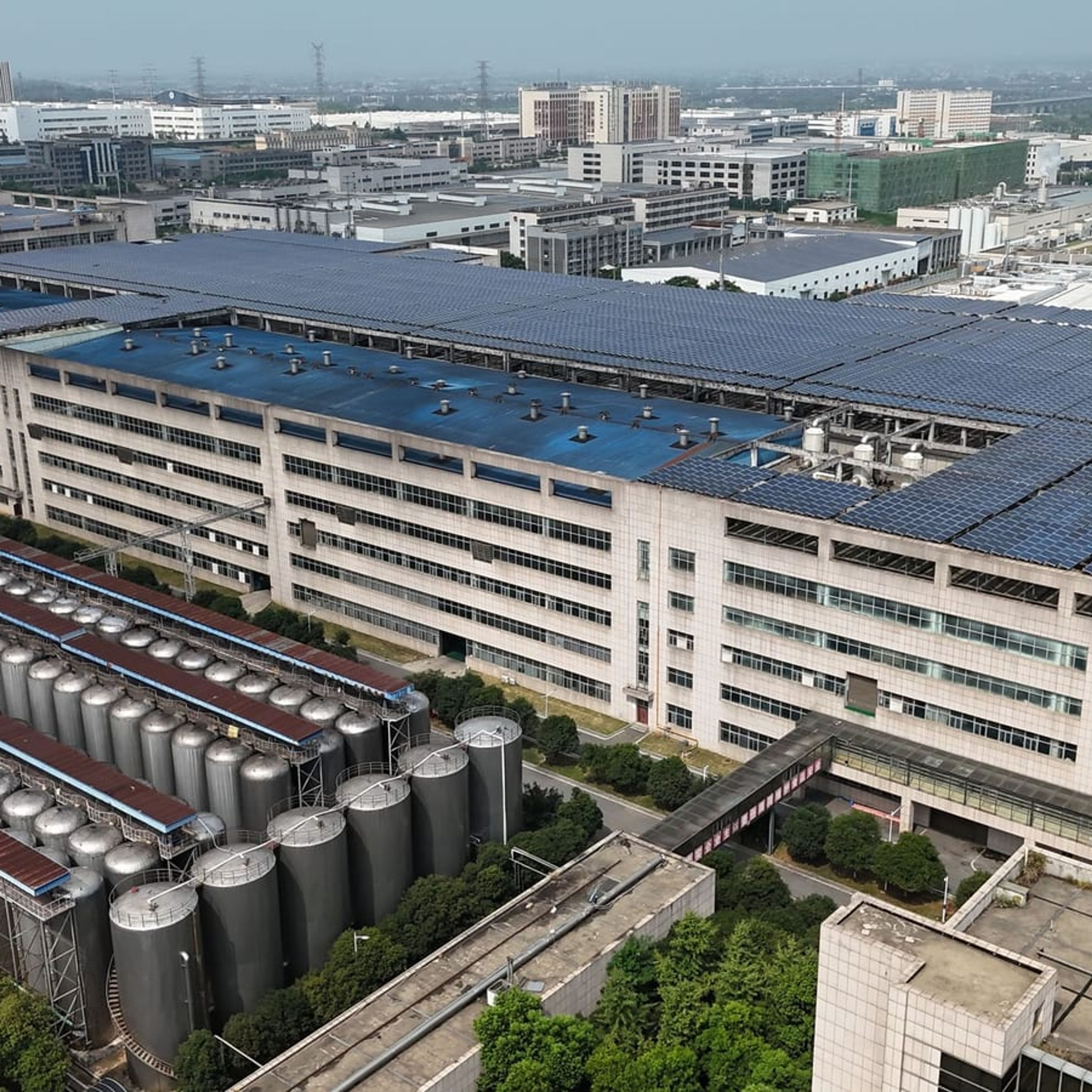 Planta industrial com grande cobertura de módulos fotovoltaicos.