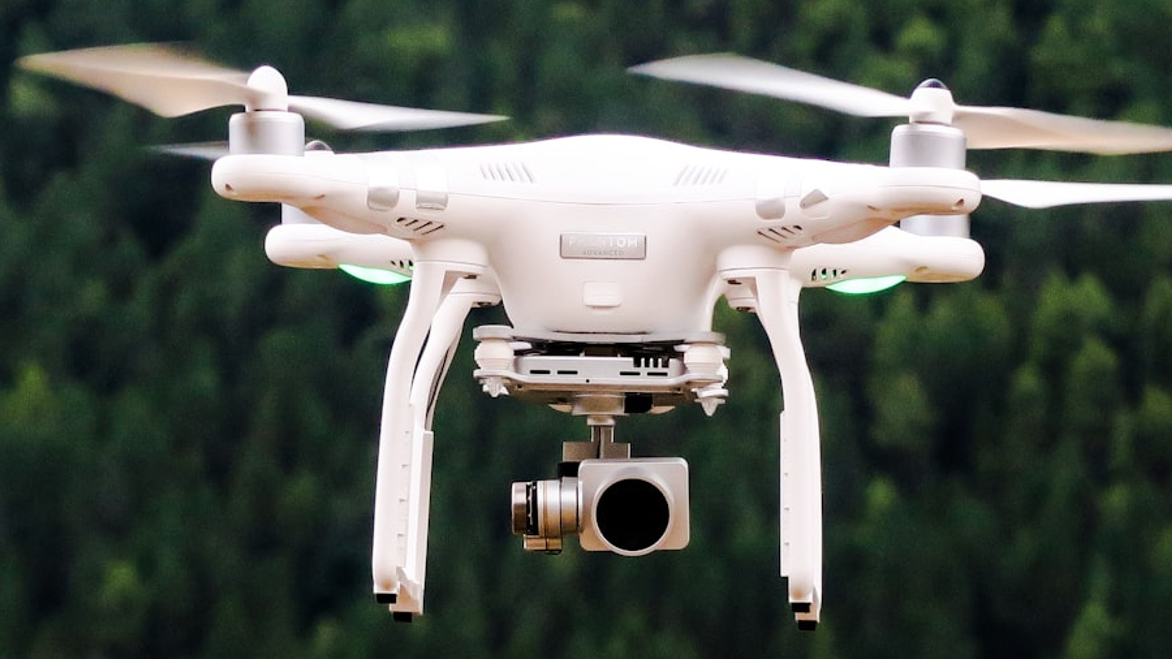 Drone de inspeção com câmera sobrevoando área verde.