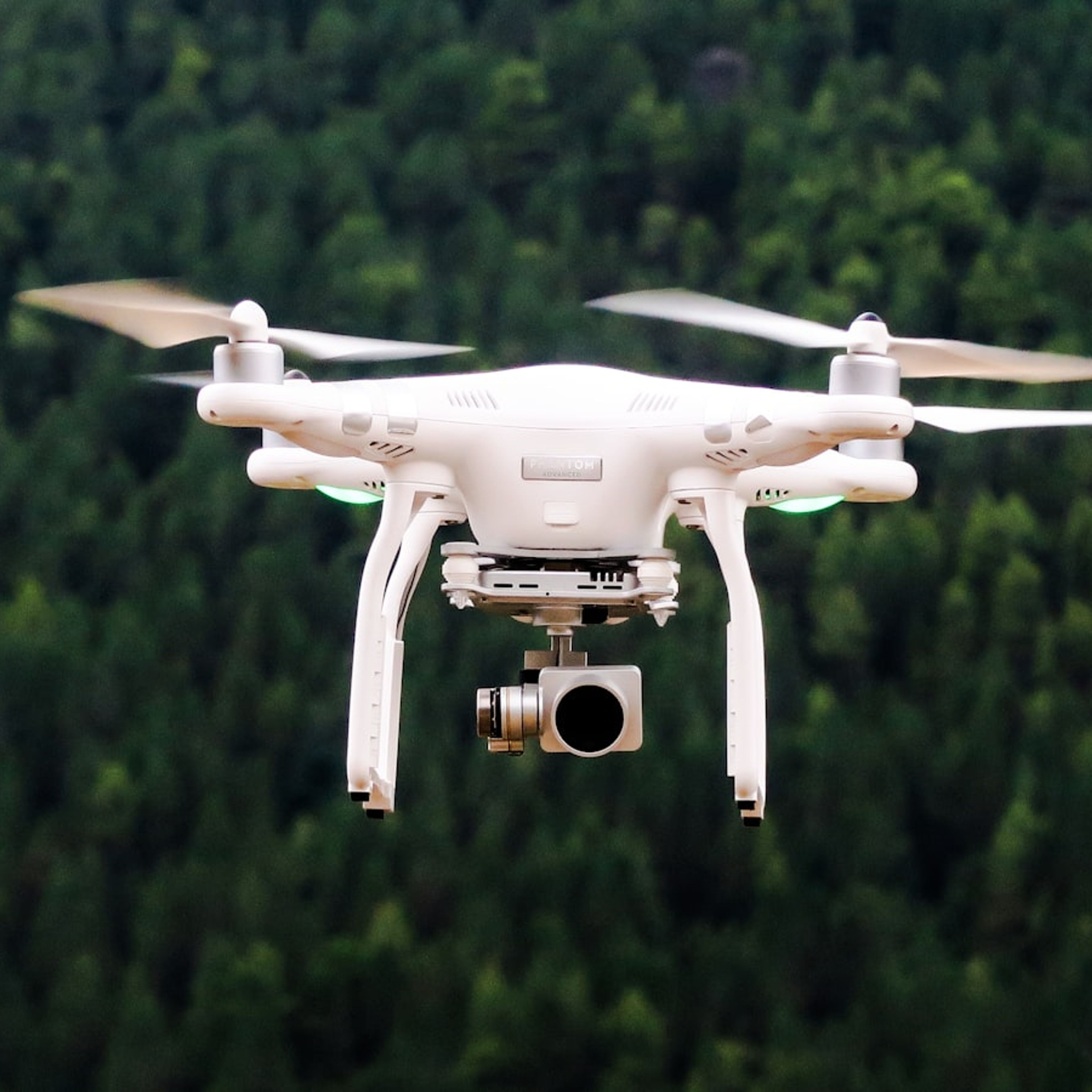Drone de inspeção com câmera sobrevoando área verde.