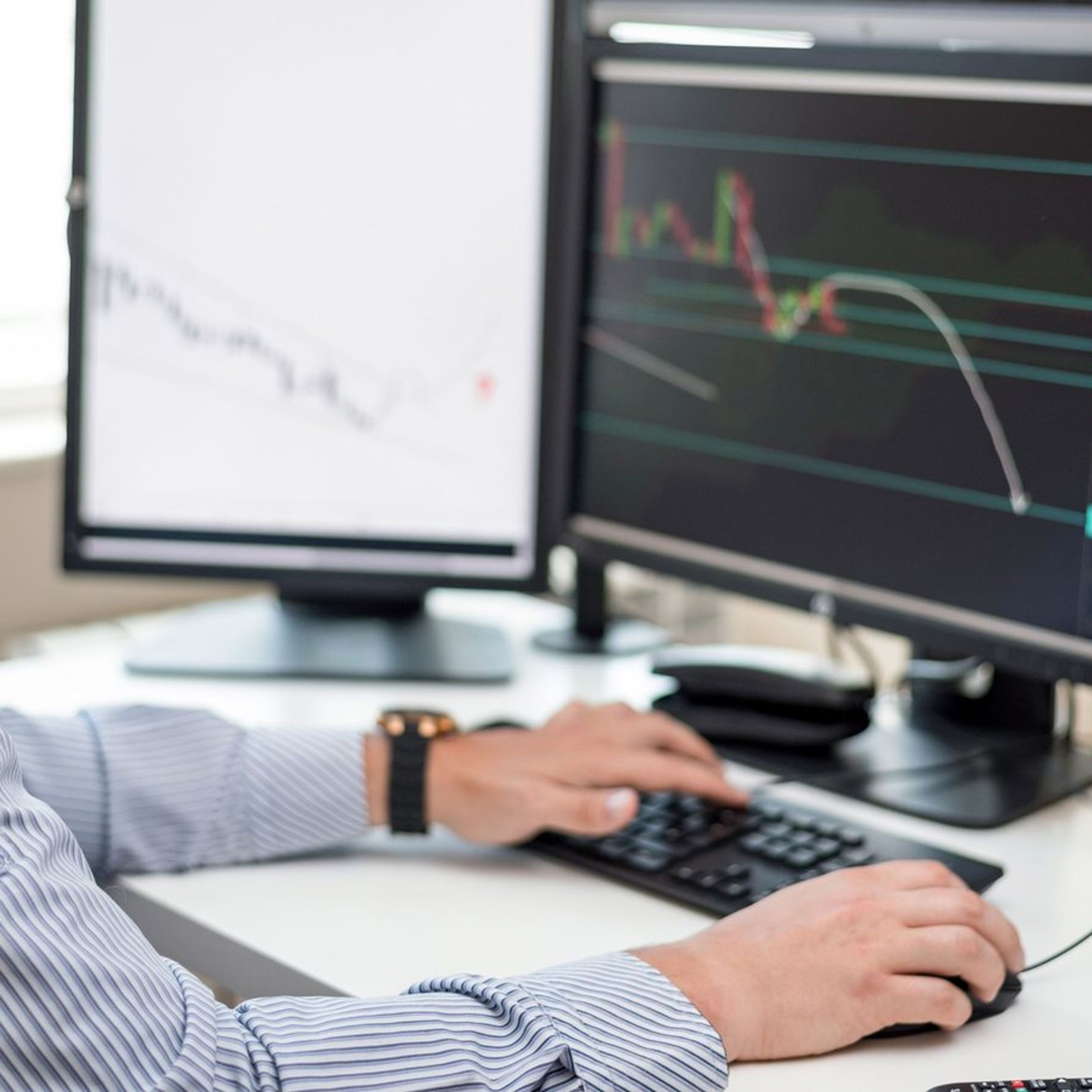 Analista examinando gráficos de dados em vários monitores.