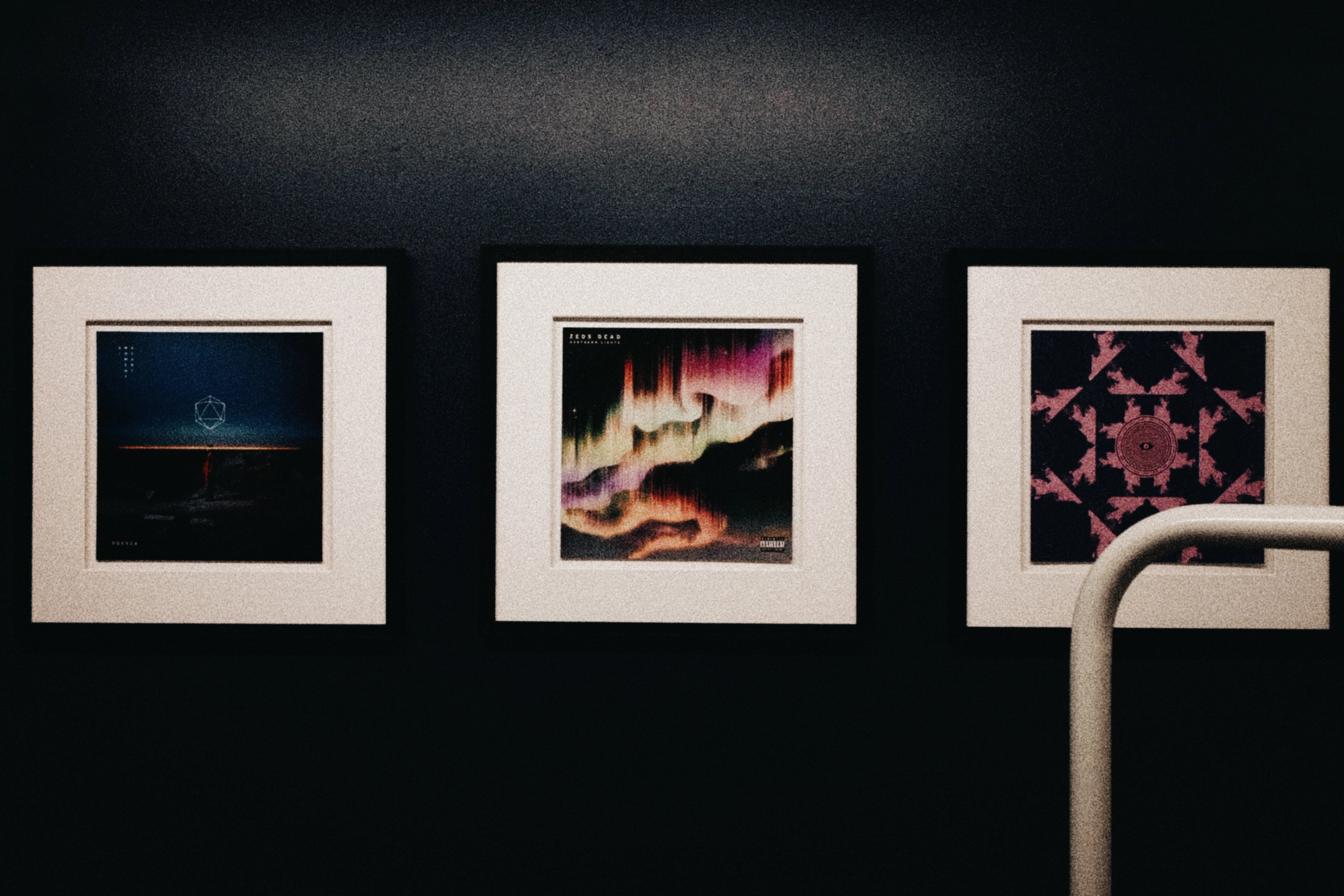 Three framed album covers hung in one of the treatment rooms, including ODESZA and Zeds Dead
