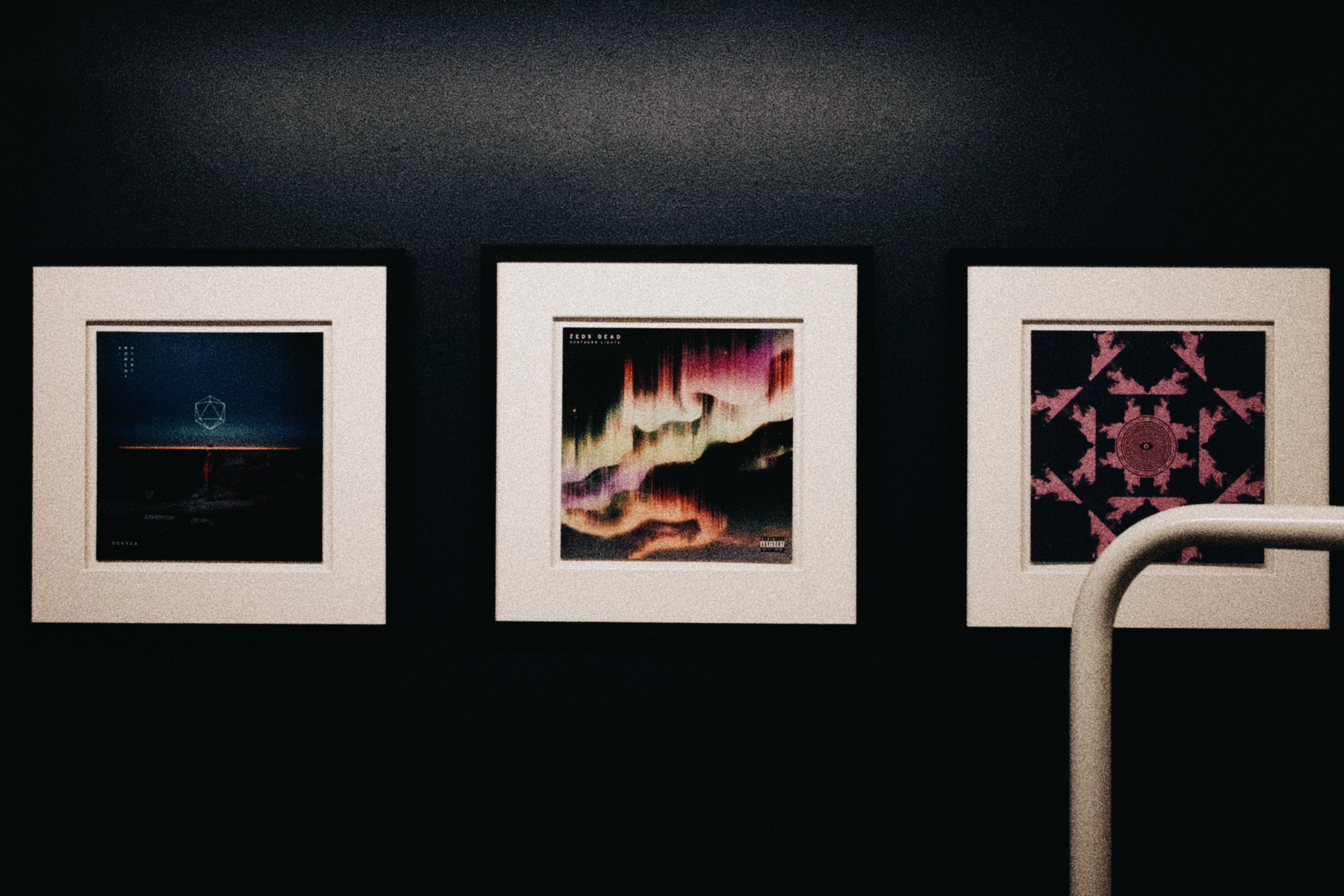 Three framed album covers hung in one of the treatment rooms, including ODESZA and Zeds Dead