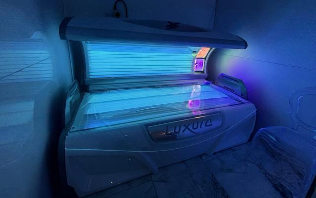 A lay-down Luxura sunbed installed in a salon room