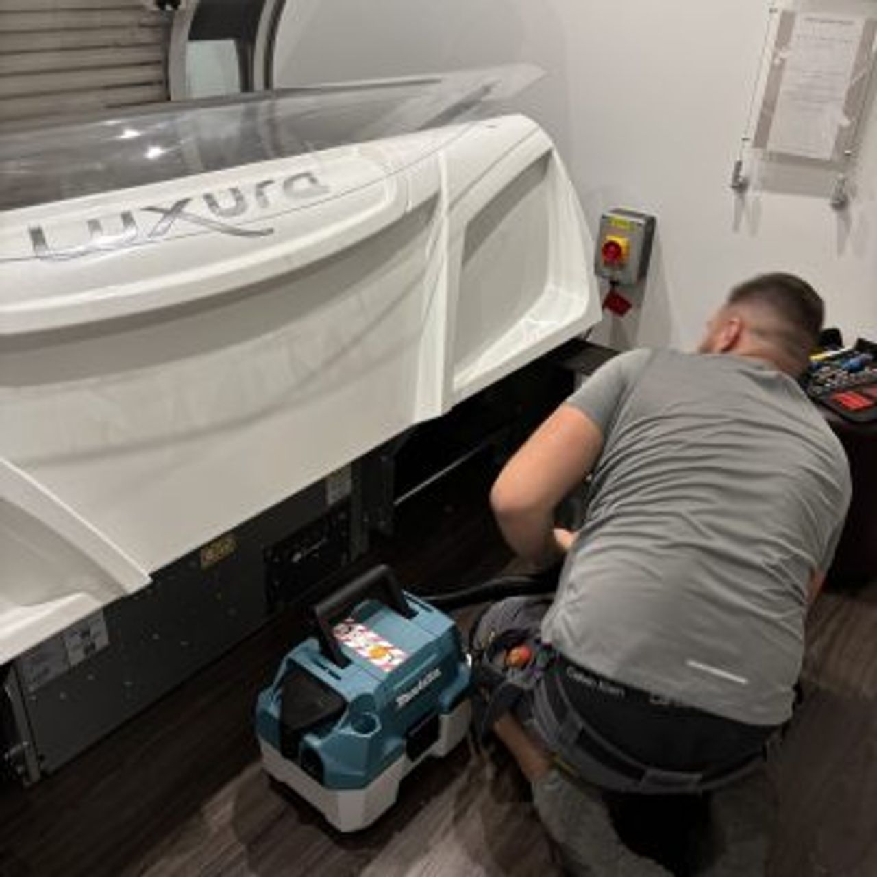 An engineer cleaning the filters of a laydown sunbed