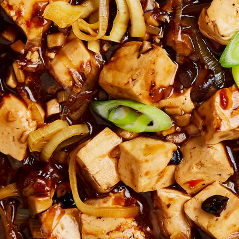 pieces of tofu in a red sauce full of chilis