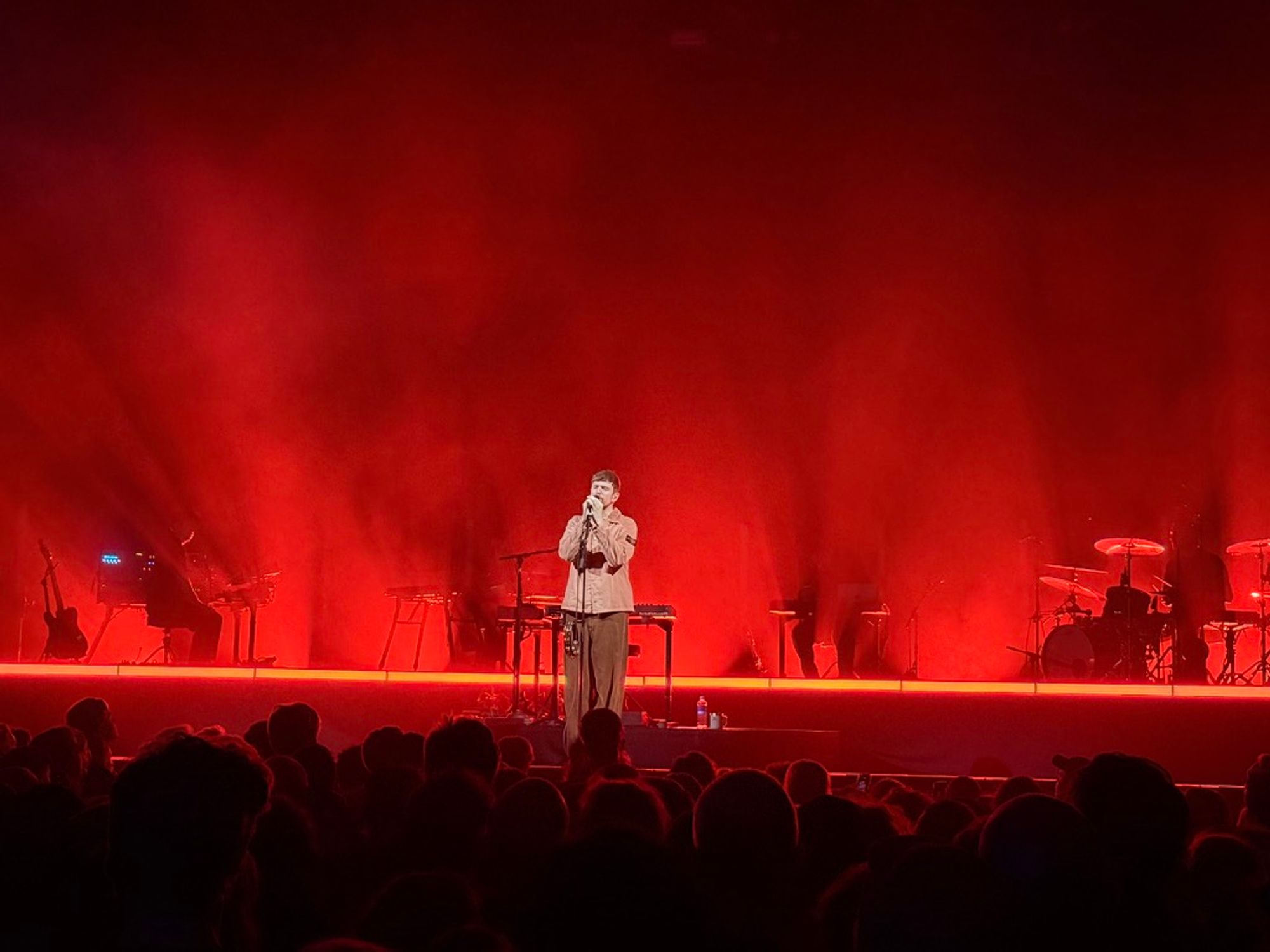james singing in mic with red lights behind him